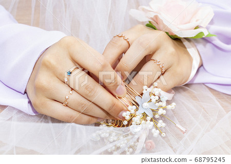 The bride is touching her hairpin to care for her hair The bride is touching her hairpin to care for her hair 68795245