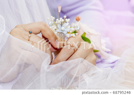 The bride is touching her hairpin to care for her hair The bride is touching her hairpin to care for her hair 68795246