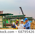 group of engineers in safety set working on outdoor construction site. 68795426