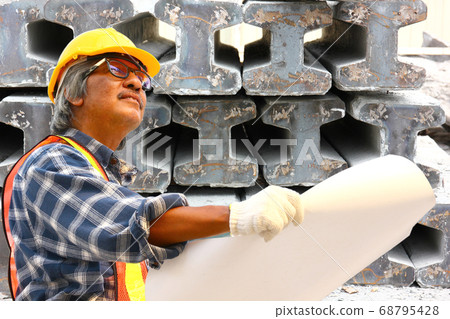 the engineer is checking product list at the factory with cement pile background the engineer is checking product list at the factory with cement pile background 68795428