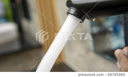 Jet streams of water running from a modern black 68795869