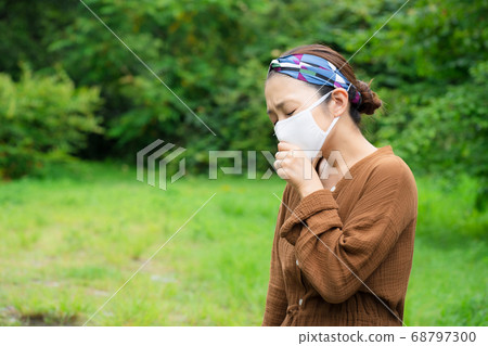 Woman wearing a mask outdoors Woman wearing a mask outdoors 68797300