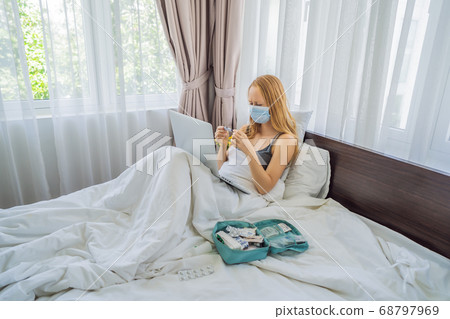Woman lies in bed and has an online consultation with doctor GP Woman lies in bed and has an online consultation with doctor GP 68797969