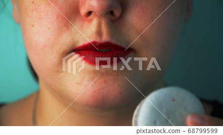 Girl eating macaroon cake close up 68799599