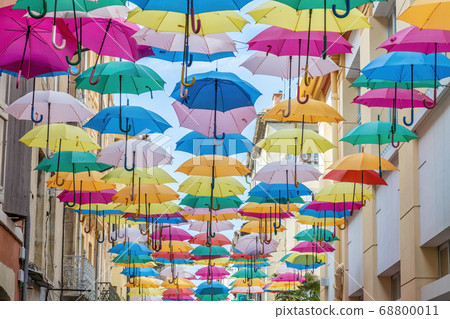 Colorful umbrellas cover a shopping street in 68800011