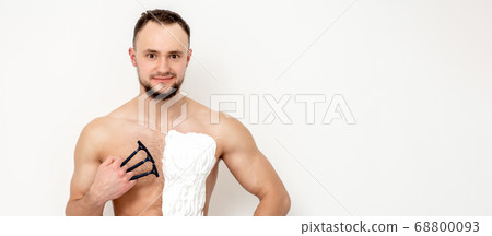 Young man shaving his chest Young man shaving his chest 68800093