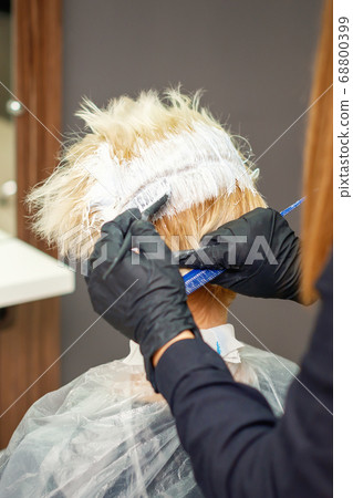 Dyeing hair of young woman. 68800399