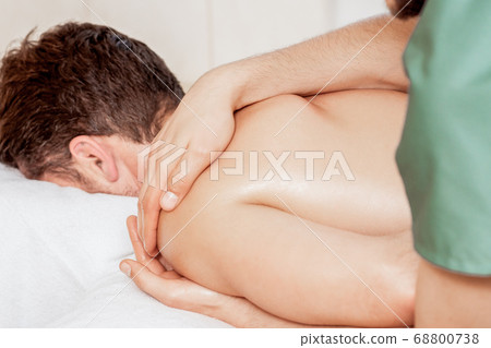 Man receiving massage on shoulder. Man receiving massage on shoulder. 68800738