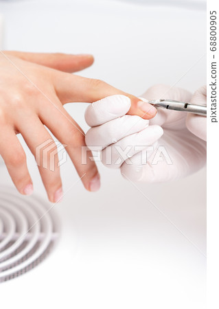 Close up of manicurist using manicure cutter Close up of manicurist using manicure cutter 68800905