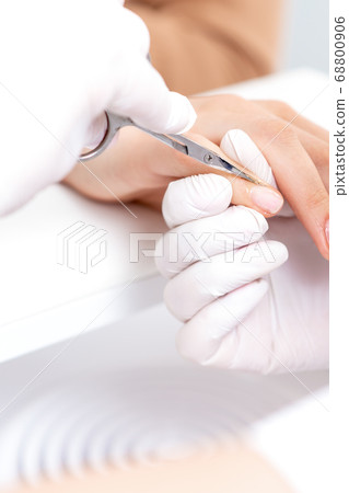 Close up of manicurist using manicure scissors Close up of manicurist using manicure scissors 68800906