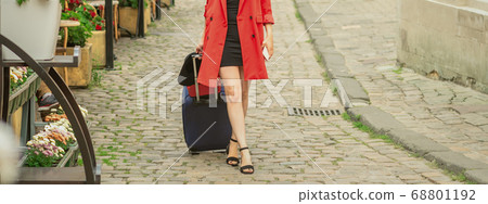 Beautiful young girl walking with blue suitcase. 68801192