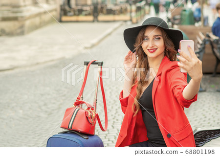 Pretty tourist girl is taking a selfie. 68801198