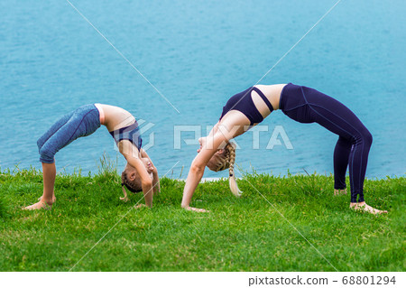 Mother and daughter doing exercise at the shore 68801294