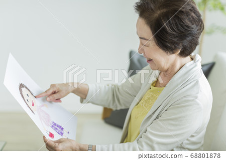 Senior woman happy looking at a caricature Senior woman happy looking at a caricature 68801878