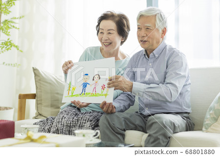 Smiling senior couple holding a caricature 68801880