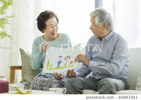 Smiling senior couple holding a caricature 68801881