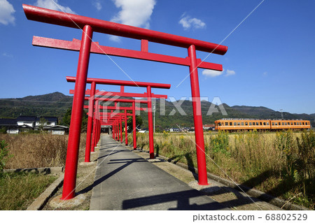 A series of red torii gates and Ichibata Electric Railway, Izumo City, Shimane Prefecture A series of red torii gates and Ichibata Electric Railway, Izumo City, Shimane Prefecture 68802529