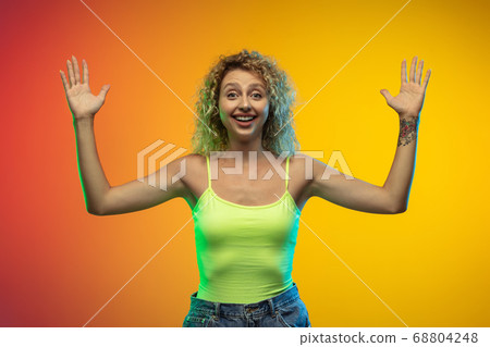 Caucasian young woman's portrait on gradient studio background in neon Caucasian young woman's portrait on gradient studio background in neon 68804248