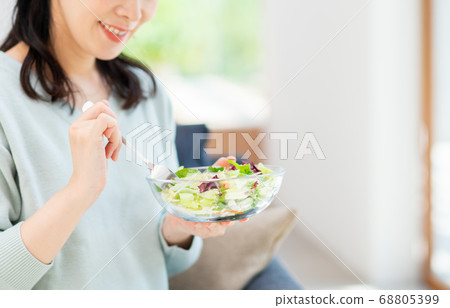 Middle-aged woman eating a salad 68805399
