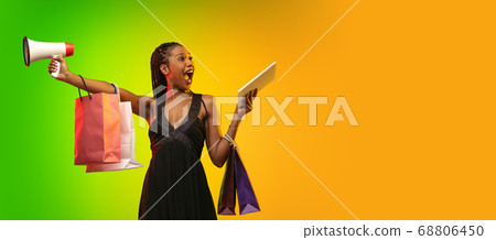 Portrait of young woman in neon light on gradient backgound. The human emotions, black friday, cyber monday, purchases, sales, finance concept. Portrait of young woman in neon light on gradient backgound. The human emotions, black friday, cyber monday, purchases, sales, finance concept. 68806450