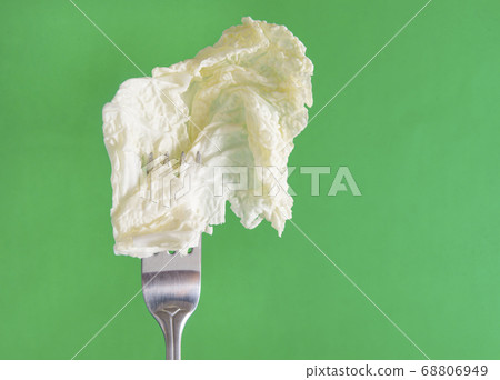 lettuce leaf on a fork on a green background lettuce leaf on a fork on a green background 68806949
