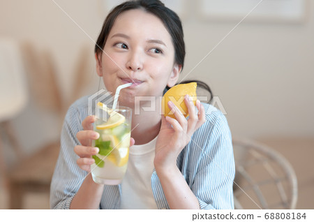Woman enjoying lemonade at home 68808184