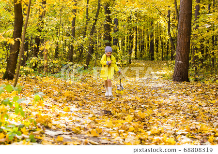 Little girl playing with her dog in autumn forest. Child and jack russell terrier dog. 68808319