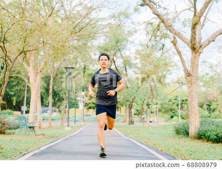 healthy Asian man running in the park in morning healthy Asian man running in the park in morning 68808979