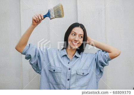 Cute girl standing near wall with repair tools 68809370