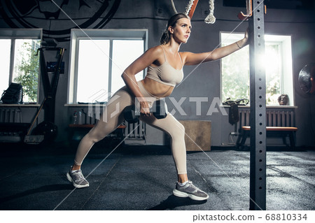 The female athlete training hard in the gym. Fitness and healthy life concept. The female athlete training hard in the gym. Fitness and healthy life concept. 68810334
