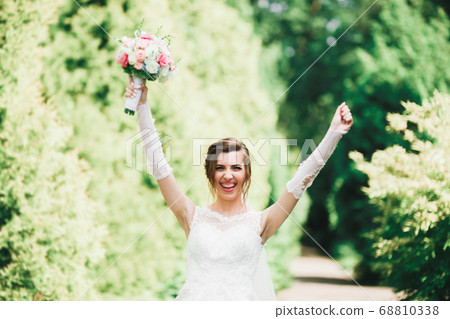 Portrait of stunning bride with long hair posing with great bouquet Portrait of stunning bride with long hair posing with great bouquet 68810338