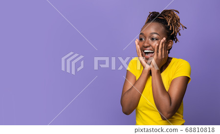 Amazed african girl with hands on cheeks looking aside 68810818
