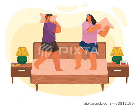 Young couple having pillow battle, man and woman enjoying time together lovers beat on bed at home Young couple having pillow battle, man and woman enjoying time together lovers beat on bed at home 68811190