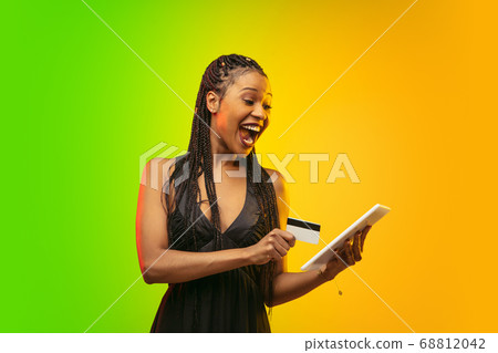 Portrait of young woman in neon light on gradient backgound. The human emotions, black friday, cyber monday, purchases, sales, finance concept. 68812042
