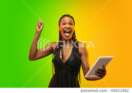 Portrait of young woman in neon light on gradient backgound. The human emotions, black friday, cyber monday, purchases, sales, finance concept. 68812062