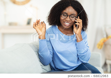 Happy girl using laptop calling her friend, sitting on sofa Happy girl using laptop calling her friend, sitting on sofa 68812063