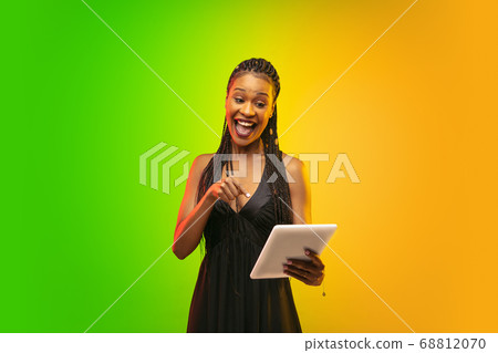 Portrait of young woman in neon light on gradient backgound. The human emotions, black friday, cyber monday, purchases, sales, finance concept. 68812070