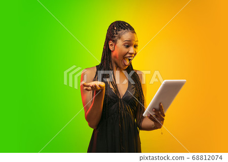 Portrait of young woman in neon light on gradient backgound. The human emotions, black friday, cyber monday, purchases, sales, finance concept. 68812074