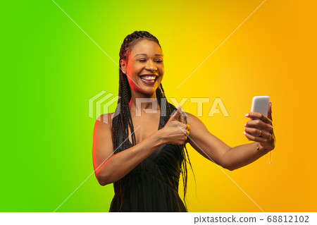 Portrait of young woman in neon light on gradient backgound. The human emotions, black friday, cyber monday, purchases, sales, finance concept. 68812102