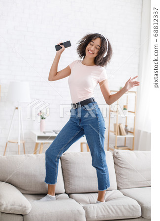 African american girl enjoying musical break at work remotely African american girl enjoying musical break at work remotely 68812337