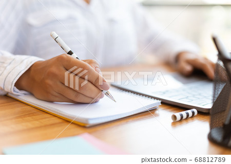 Cropped image of female manager taking notes with pen Cropped image of female manager taking notes with pen 68812789