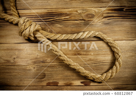 Deadly loop of rope on a wooden background. 68812867