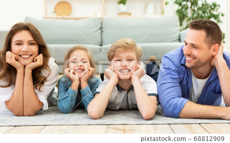 Happy Family Of Four Lying On Floor Posing At Home Happy Family Of Four Lying On Floor Posing At Home 68812909