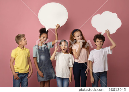 Cute multinational schoolchildren with empty speech bubbles over pink background, space for design 68812945