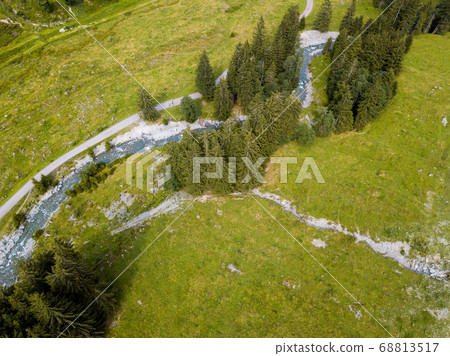 Aerial view on trees, paths and a creek used by people for refreshment in the skiing region of Hinterglemm in the Alps in Austria on a sunny summer day Aerial view on trees, paths and a creek used by people for refreshment in the skiing region of Hinterglemm in the Alps in Austria on a sunny summer day 68813517