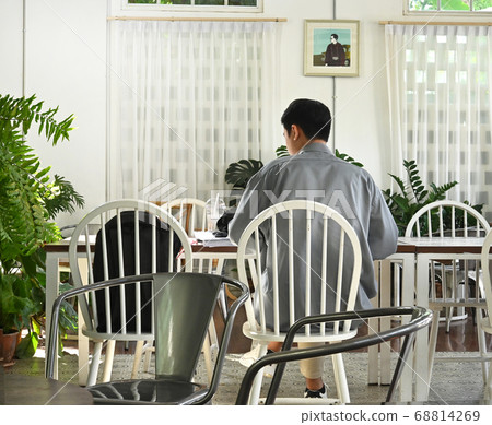 A man life in social stages; A man working in a coffee shop at social distances. 68814269