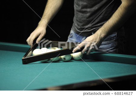 Playing billiard: player setting up balls for the 68814627