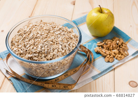 oat flakes in a glass plate, nuts and apples on a 68814827