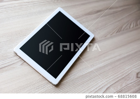 White tablet pc with empty screen on wood White tablet pc with empty screen on wood 68815608