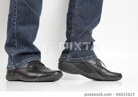 Men's legs in jeans and black classic shoes on Men's legs in jeans and black classic shoes on 68815825
